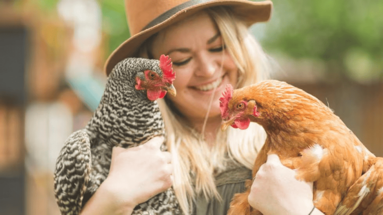 A woman holding two chickens