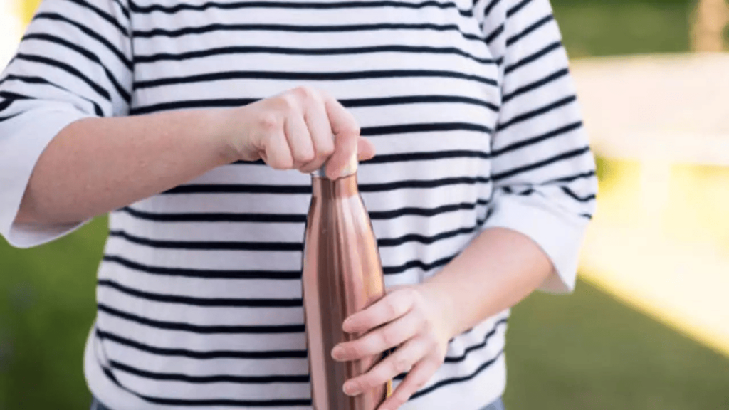 Drinking from a copper bottle outdoors